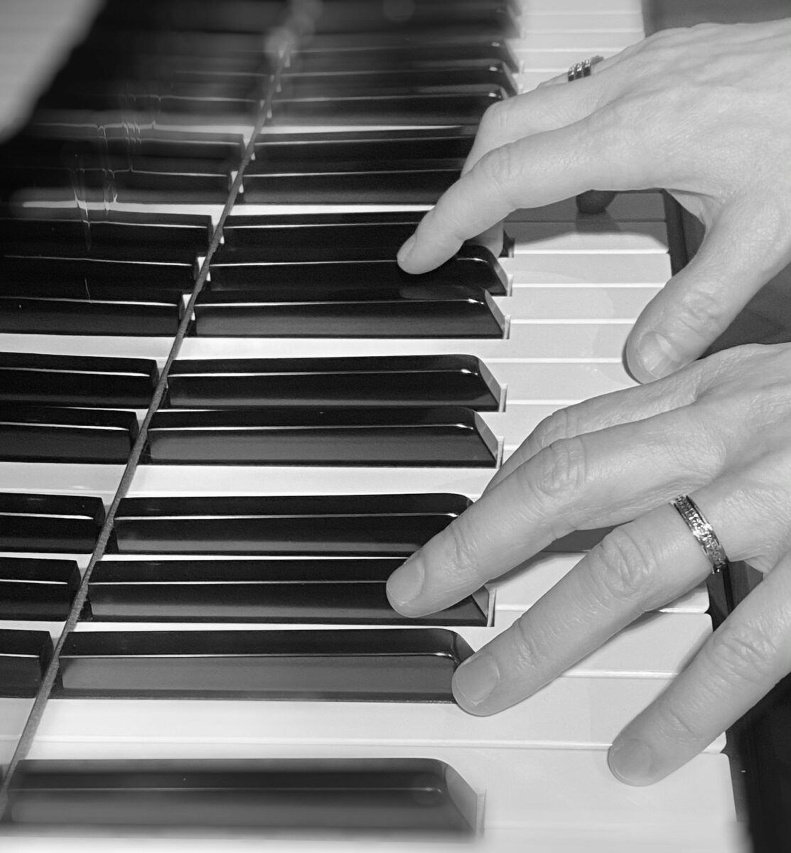 Kyrkomusiker IA Arhusiander spelar piano. Hennes fingrar dansar över pianots tangenter
